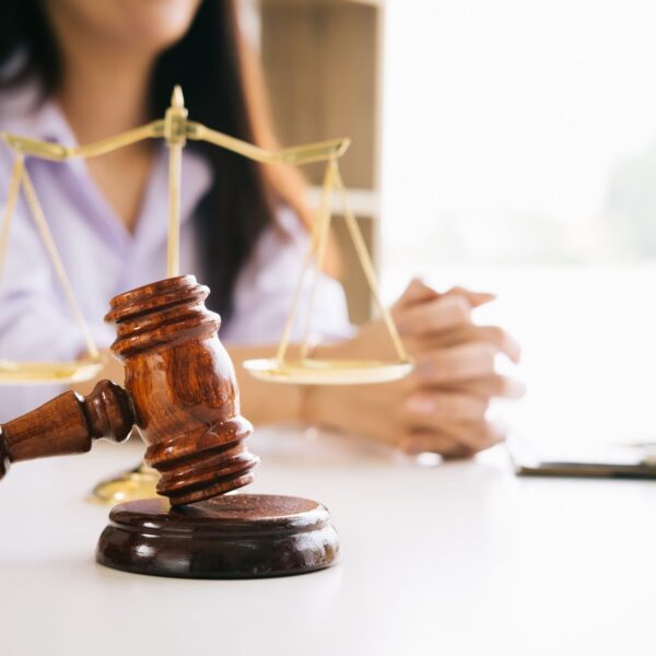 judge's gavel and scales of justice on a desk in a courtroom